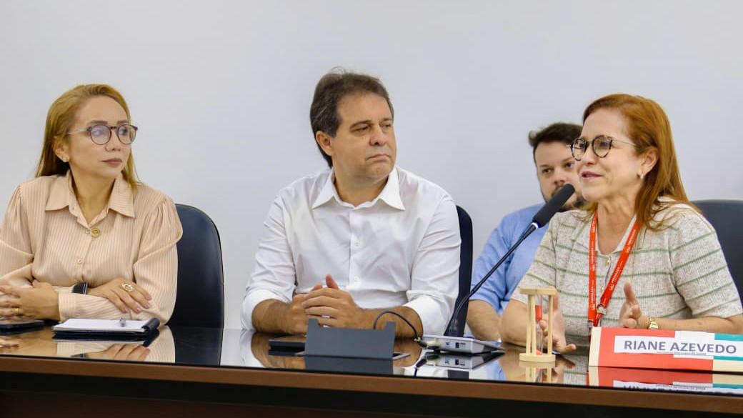 prefeito evandro e secretária riane azevedo e aline gouveia numa mesa de reunião